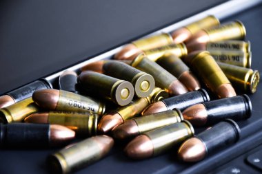 9mm 'lik tabanca mermileri taplet klavyesi ve ekranında, yumuşak ve seçici odak, veritabanını aramak ve depolamak için akıllı aygıtlar kullanarak kurşun türleri öğrenmek için konsept.