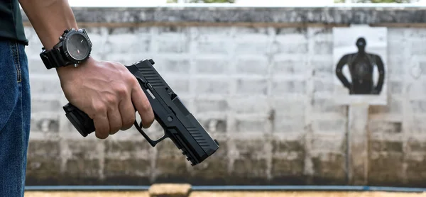 9mm automatic pistol holding in right hand of shooter, concept for security, robbery, gangster, bodyguard around the world. selective focus on pistol