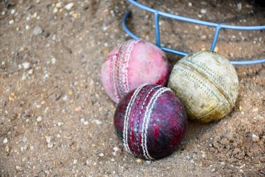 Kriket spor malzemeleri, eski deri top, tahta sopa, kortta kask, yumuşak ve seçici odaklanma..