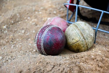 Kriket spor malzemeleri, eski deri top, tahta sopa, kortta kask, yumuşak ve seçici odaklanma..