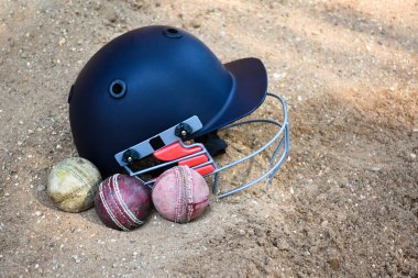 Kriket spor malzemeleri, eski deri top, tahta sopa, kortta kask, yumuşak ve seçici odaklanma..