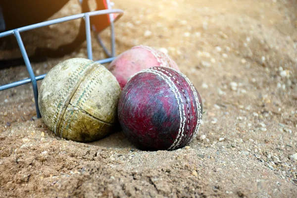 Kriket spor malzemeleri, eski deri top, tahta sopa, kortta kask, yumuşak ve seçici odaklanma..