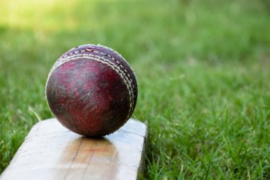 Kriket spor malzemeleri, eski deri top, tahta sopa, kortta kask, yumuşak ve seçici odaklanma..