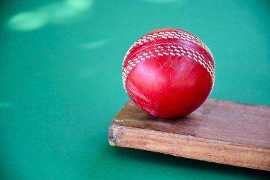 Kriket antrenmanı için kullanılan koyu arka planda eski ve kullanılmış kriket topu, yumuşak odaklanma.