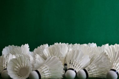 İzole edilmiş ve yeşil arka planda eski badminton topları, yumuşak ve seçici odaklanma.