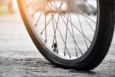 Kaldırıma park etmiş klasik bisikletin ön lastiği, yumuşak ve seçici bir odak noktası..