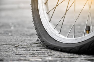 Kaldırıma park etmiş klasik bisikletin patlak arka lastiği. Yumuşak ve seçici odaklı..