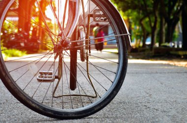 Kamu parkında dar bir sokağa park edilmiş klasik bisikletin ön tekerleği, yumuşak ve seçici odak, klasik bisiklet konsepti..