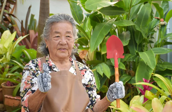 Een Oude Aziatische Vrouw Een Bloemenjurk Trekt Handschoenen Aan Draagt — Stockfoto