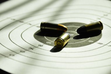 9mm 'lik tabanca mermileri hedef kağıt üzerinde, yumuşak ve seçici odaklı..