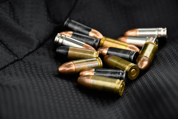 9mm pistol bullets on black leather floor, soft and selective focus on, concept for training and practising shooting to protect life and properties around the world.