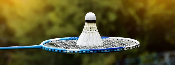 White Cream Badminton Shuttlecock Blue Badminton Racket Outdoor Blurred Trees — Stockfoto