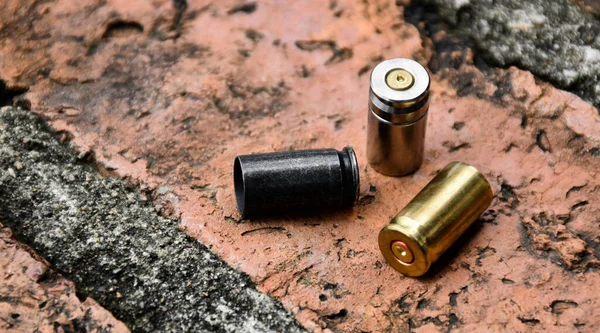 9mm pistol bullets and bullet shells on brick floor, soft and selective focus on black bullet shell, concept for searching a key piece of evidence in a murder case at the scene.