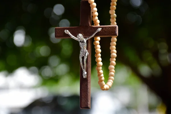 Dřevěný Kříž Náhrdelník Korálky Visí Přírodní Rozmazané Bokeh Stromy Pozadí — Stock fotografie