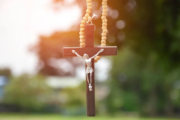 Collana Perle Legno Croce Appesa Sfondo Naturale Bokeh Sfocato Alberi — Foto Stock