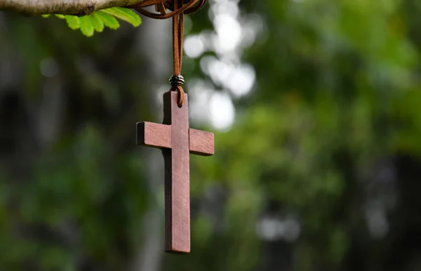 木の枝に掛かった木の十字架 柔らかく選択的な焦点 自然なボケの木の背景 許しと世界中のイエスへの信仰のための概念 — ストック写真