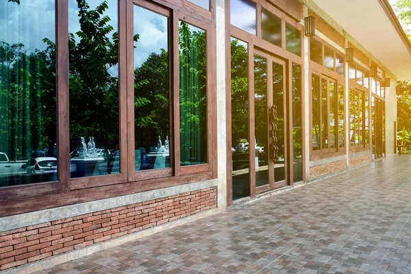 Side view of balcony window of the house made of bricks, wood and large glasses, soft and selective focus.