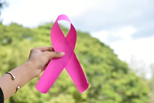 女性の10代の若者の手によるピンクの紙のリボンは 世界中のすべての人々を支援し 女性の乳がんキャンペーンに出席するために呼び出すために ソフトと選択的フォーカス — ストック写真