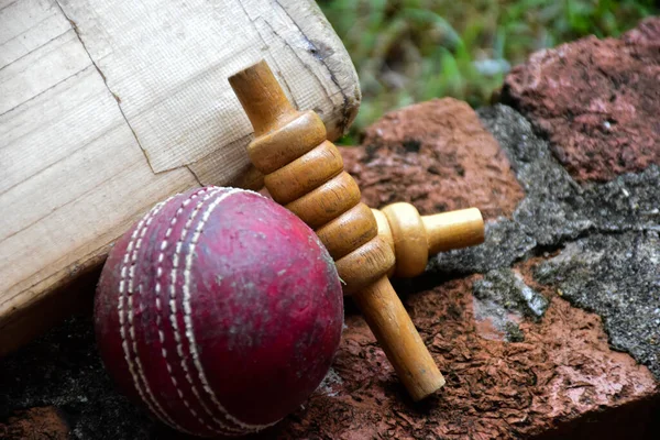 Old and unused cricket sport equipments on brick, bat, wicket, old leather ball, soft and selective focus.
