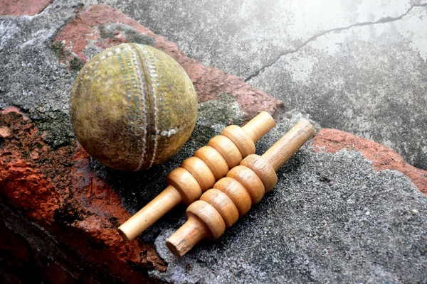 Old and unused cricket sport equipments on brick, bat, wicket, old leather ball, soft and selective focus.