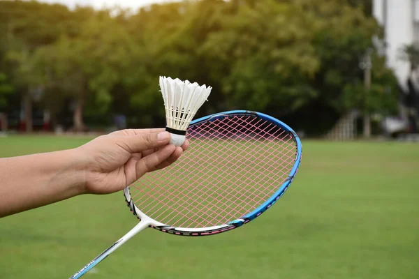 Badminton racket and badminton shuttlecocks holding in hands for outdoor playing, soft and selective focus on string and racket, concept for outdoor activity.
