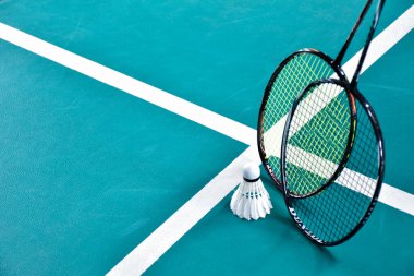 Beyaz badminton topu ve raketi kapalı badminton kortunda, kopyalama alanı, mekik horozlarına yumuşak ve seçici odaklanma.