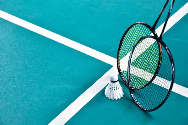 Beyaz badminton topu ve raketi kapalı badminton kortunda, kopyalama alanı, mekik horozlarına yumuşak ve seçici odaklanma.