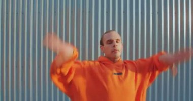 Kapüşonlu şık dans eden Igbt 'ci dışarıda çitlerin arkasında zarif modern dans gösterisi yapıyor. Cinsiyet kimliği