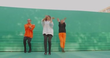 Dans takımı performansı, şık dansçılar yeşil arka planda çağdaş ateşli kışkırtıcı dans gösterisi