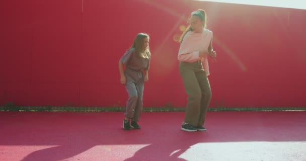 Werbevideo der Tanzschule. Tänzerin mit gemischter Rasse bringt Teenie-Mädchen bei, die draußen im Sonnenlicht tanzen — Stockvideo