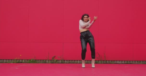 Menari gadis muda yang cantik melakukan tarian seksi bergairah di luar dengan latar belakang merah. Penampilan penari yang anggun — Stok Video