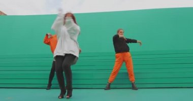 Dans eden insanlar, havalı dansçılar dışarıda yeşil arka planda çağdaş dans ediyorlar. Müzik klibi için reklam videosu