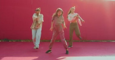 Gün ışığında dans eden kızlar. Profesyonel bayan dansçılar enerjik sokak dansı hareketleri sergiliyorlar.