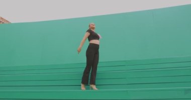 Dans eden mutlu genç kız dışarıda enerjik bir çağdaş dans sergiliyor. Modern pozitif kadın dansçı.