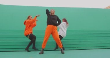 Dans eden insanlar, havalı dansçılar, yeşil arka planda eğlenmek için çağdaş sokak dansı yapıyorlar.