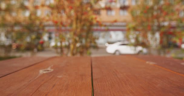 Tampo de mesa texturizado de madeira vazio com fundo de paisagem de rua desfocado desfocado de transporte em movimento — Vídeo de Stock