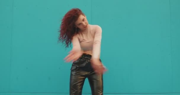 跳舞的卷曲的年轻姑娘在蓝色背景下在外面跳着激情的舞.女舞者性感动人，挥动着头发 — 图库视频影像