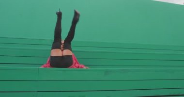 Yüksek topuklu giyen dans eden Igbt 'li adam dışarıda yeşil arka planda zarif tutkulu Vogue Femme dansı yapıyor.