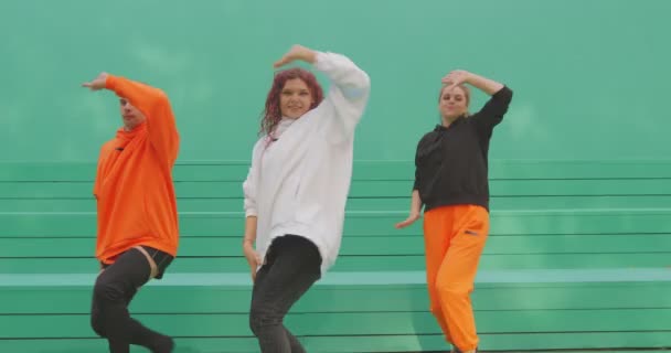 Танцювальна команда, стильні танцюристи виконують сучасний танець на зеленому фоні. Рекламне відео для кліпу — стокове відео