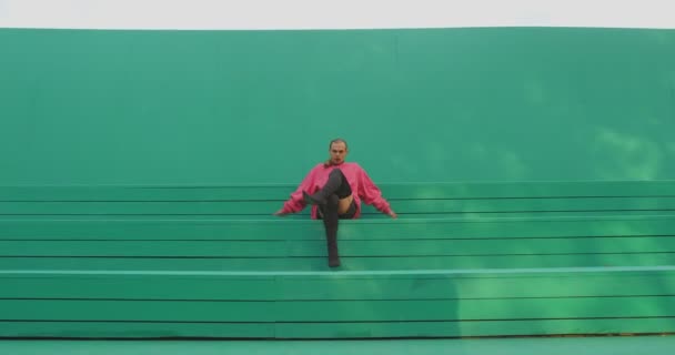 穿着高跟鞋跳舞的lgbt家伙专业舞蹈演员在户外的绿色舞台上表演激情的性感舞蹈 — 图库视频影像