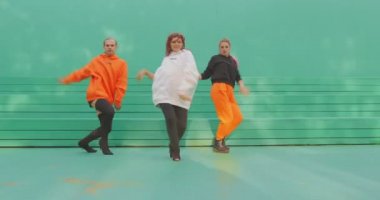 Dans takımı, şık dansçılar yeşil arka planda kışkırtıcı danslar yapıyorlar. Müzik klibi için reklam videosu