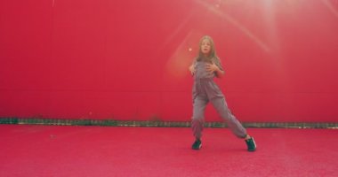 Dans eden genç kız dışarıda günışığında enerjik, modern sokak dansı yapıyor. Genç dansçı güzel hareket.
