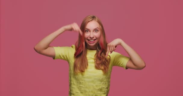 Щаслива молода дівчина вказує пальцем вниз, рекомендує посилання нижче, місце для рекламної інформації, реклами — стокове відео