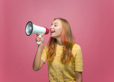 Megafonlu mutlu genç kız haberleri duyur, reklamları duyur, pembe arka planda hoparlör kullanarak uyar.