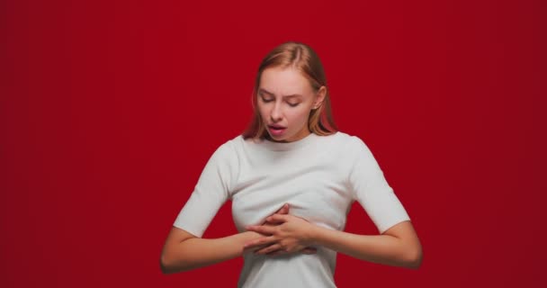 Krankes junges Mädchen leidet unter Brustschmerzen, Schmerz, Angst vor Herzinfarkt oder Infarkt Symptom auf rotem Studiohintergrund — Stockvideo