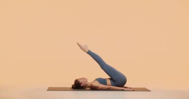 Yogi kızı yoga çalışmasında Plow Poose ya da Halasana 'yı stüdyoda gösteriyor. Sağlıklı omurga ve kadın sağlığı için pilates çalışması.