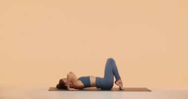 Yoga yapan genç kız stüdyoda tekerlek pozu veriyor. Mükemmel vücut, kadın sağlığı ve sağlıklı yaşam tarzı.