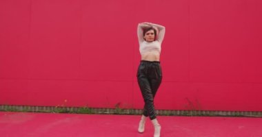 Red Street duvarında dans eden havalı genç ve çekici bir kız. Çağdaş femme dansı. Modern seksi kadın dansçı