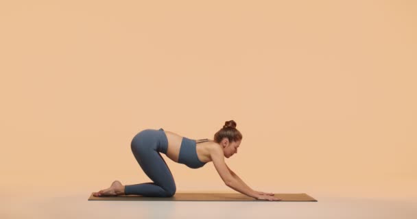 ヨガ練習スタジオチュートリアルビデオ。ヨギ女性インストラクターは、健康的な柔軟な背骨、女性の健康のための演習を示しています — ストック動画