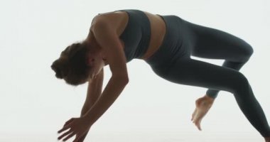 Kadın sağlığı için yoga pratiği. Uygun, zarif, esnek genç kız Vahşi Şey Pozu veriyor. Pilates stüdyosu çalışması